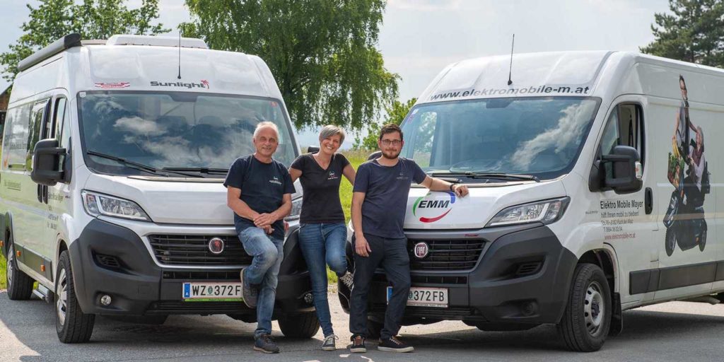 Elektromobile Team mit zwei Firmenbussen